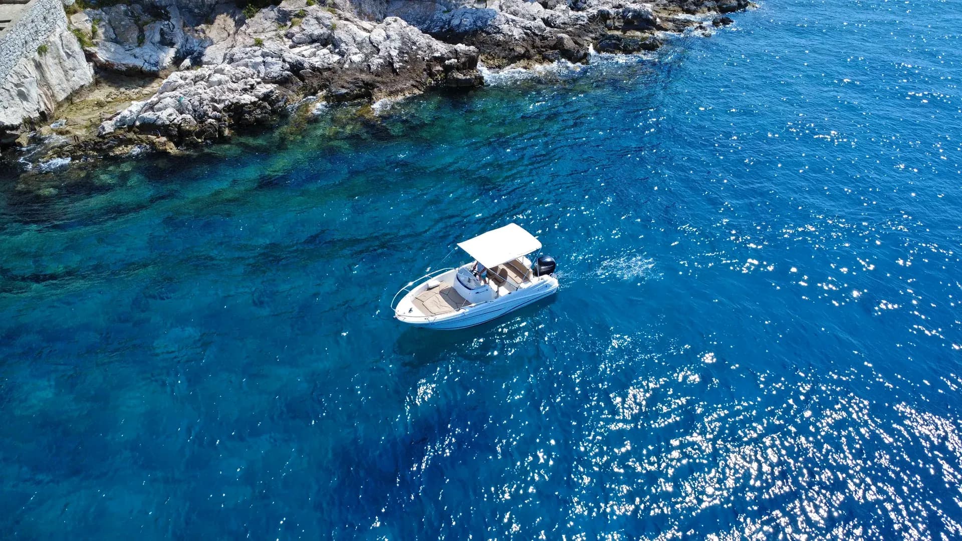 Our modern fleet — speedboat anchored in a crystal clear cove near Hvar